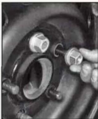 Close-up of a hand adjusting a mechanical component with threaded parts (no visible text or symbols)