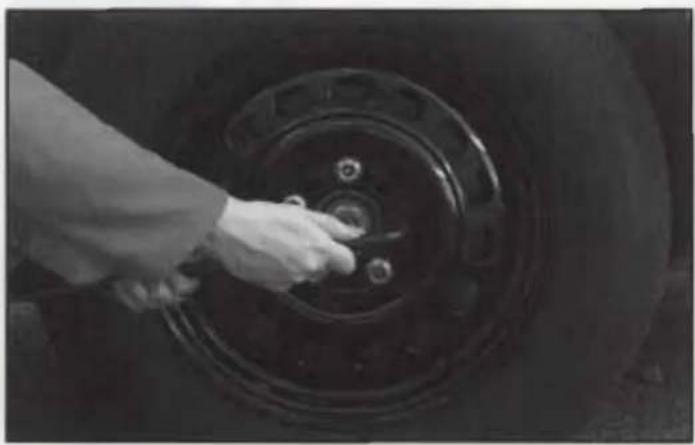 Close-up of a hand adjusting a car tire wheel (no visible text or symbols)