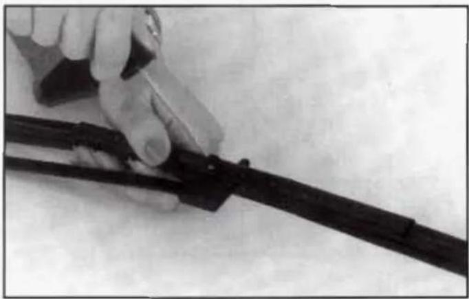 Close-up of a hand holding a black cable with a small connector, against a plain background (no text or symbols visible)