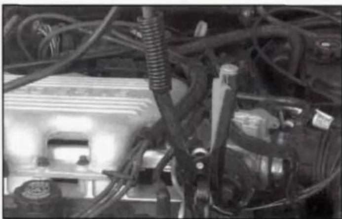 Close-up of automotive engine components including hoses, springs, and motors (no visible text or symbols)