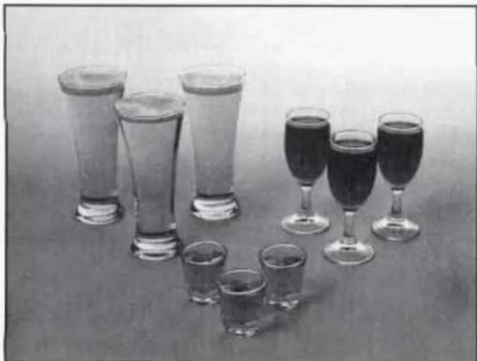 Black-and-white photo of multiple glasses and wine glasses arranged on a table, no text or symbols visible