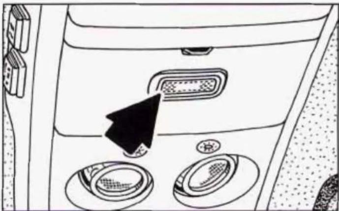 Interior view of a car dashboard with directional arrow and circular buttons (no text or symbols)