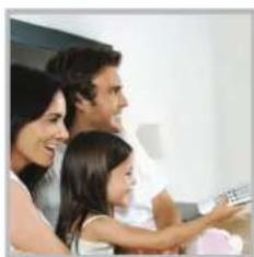 Family of three smiling and watching TV (no visible text or symbols)