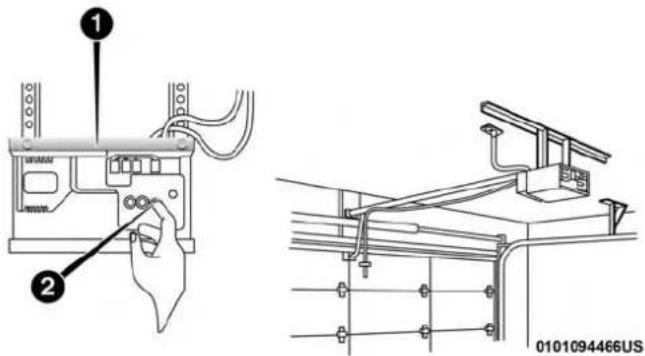 Technical diagram showing installation of a device with labeled components and wiring, including a hand holding a cable.