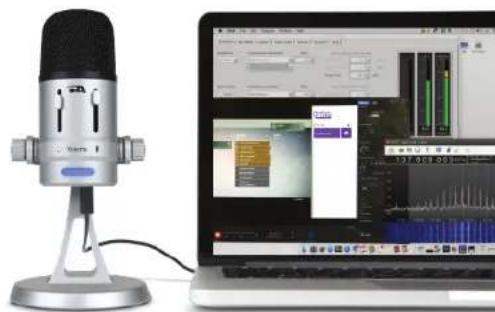 Studio setup featuring a desktop microphone and a laptop displaying audio interface (no visible text or symbols)