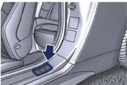 Interior view of a car showing the side panel and seat, with a blue arrow pointing to the seat area (no text or symbols visible)
