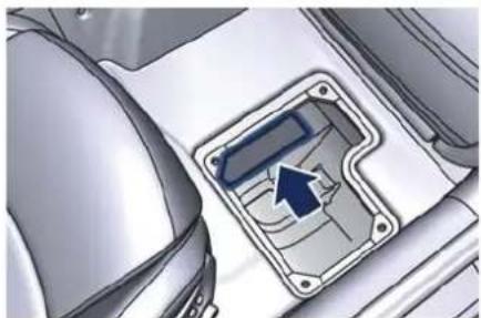 Close-up of a car interior panel with a blue arrow pointing to a component (no visible text or symbols)