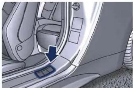 Interior view of a car showing the side panel and seatbelt, with a blue arrow pointing to the door (no text or symbols visible)