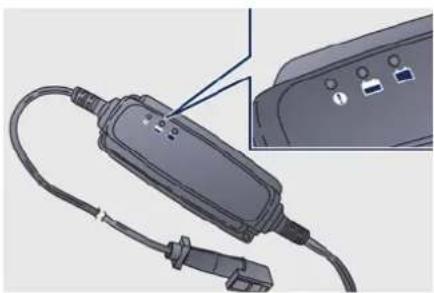 Illustration of a handheld electronic device with cable and connector, showing internal components and a close-up inset (no text or symbols)
