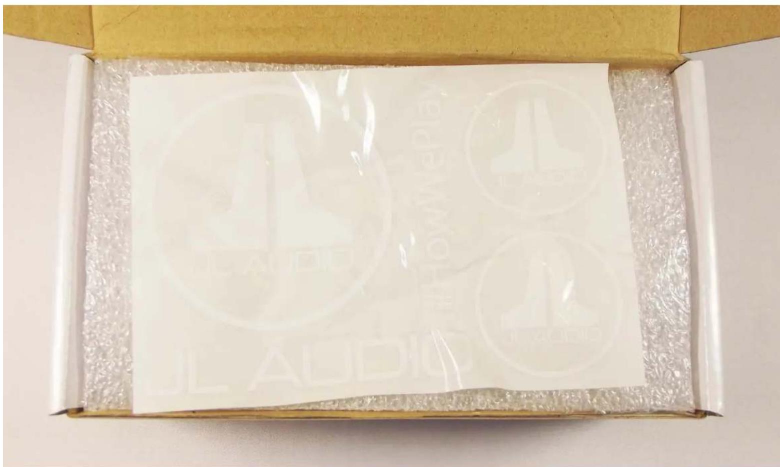 Open cardboard box with printed circular seals and Chinese characters, showing a transparent plastic cover.