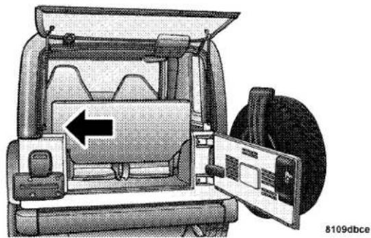 Interior view of a vehicle showing the rear compartment with a door open, no visible text or symbols
