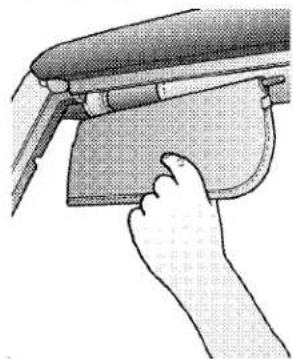 Hand holding a small rectangular object with a curved handle, next to a flat surface (no text or symbols visible)