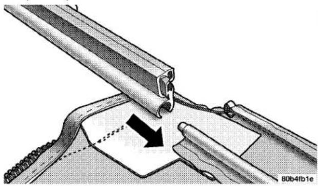 Technical illustration of a mechanical assembly with a tool and component, showing a directional arrow (no text or symbols)