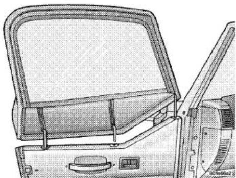 Technical line drawing of a vehicle rear compartment showing lid, door, and control panel (no text or symbols)
