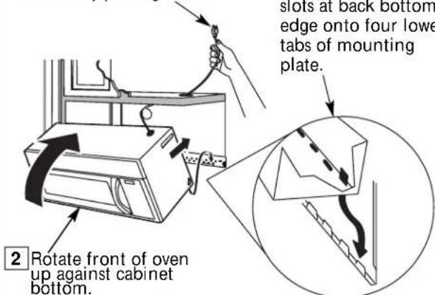slots at back bottom edge onto four lowe tabs of mounting plate. 2 Rotate front of oven up against cabinet bottom.