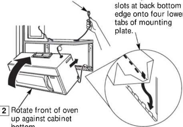 slots at back bottom edge onto four lower tabs of mounting plate. 2 Rotate front of oven up against cabinet bottom.