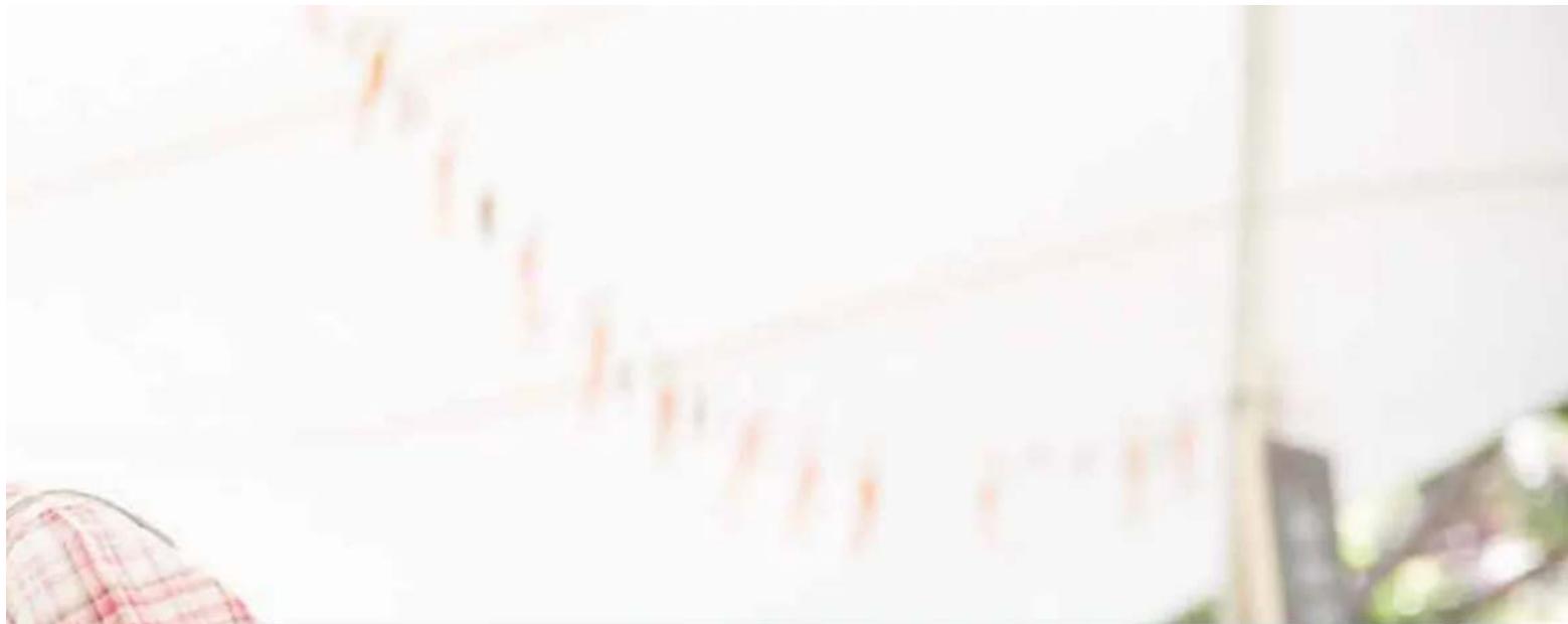 Blurred image showing a financial chart with red and white text, partially obscured by a hand holding a checkered flag.