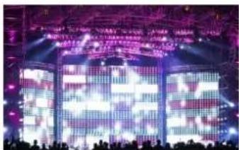 Stage photo with large illuminated Chinese characters on purple and white backgrounds, surrounded by silhouetted audience.
