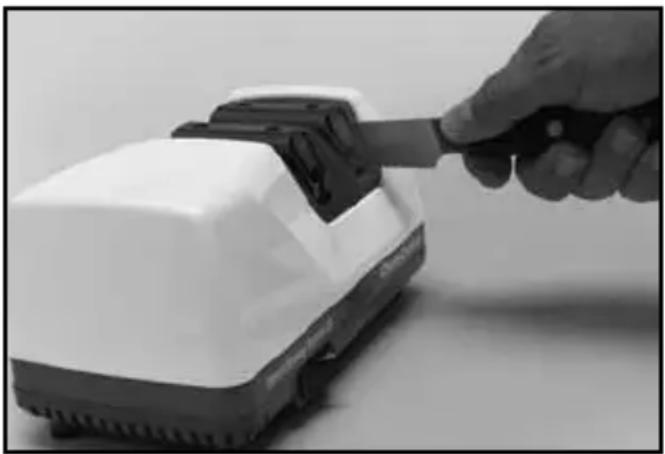 Hand inserting a plug into a white electronic device (no text or symbols visible)