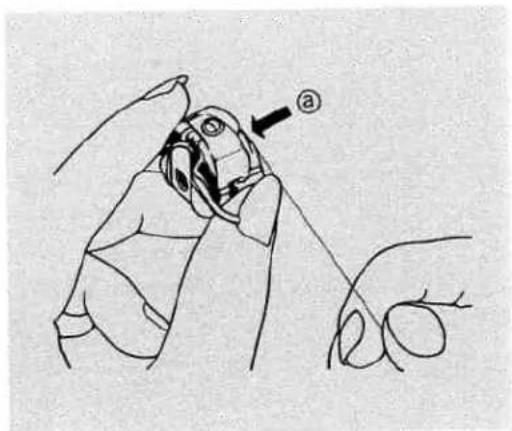 Diagram showing a hand holding a small object with an arrow labeled 'a' pointing to it, likely illustrating a mechanical or anatomical procedure.