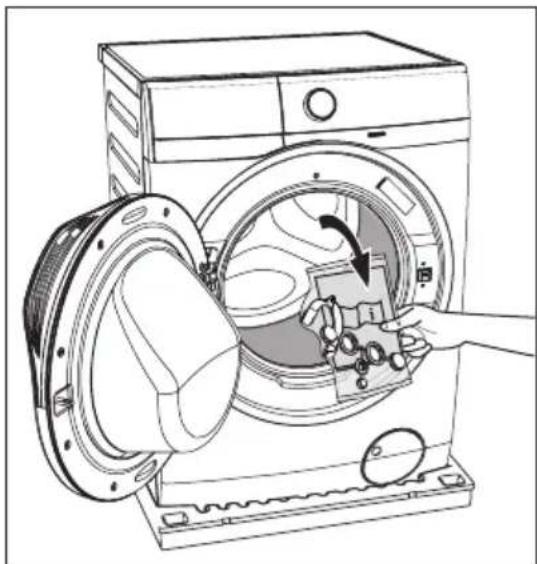 Line drawing of a washing machine with a hand inserting a fan into the chamber (no text or symbols)