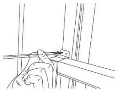 Line drawing of a hand holding a tool near a metal bracket (no text or symbols)