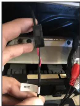 Close-up of hands installing a component labeled 'MIC' into a battery pack (no readable text beyond label)