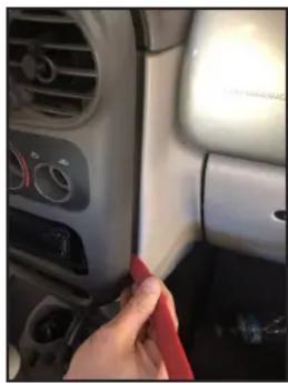 Close-up of a car interior showing a hand cleaning the dashboard with a red cloth (no visible text or symbols)