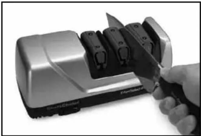 Close-up of a hand using a knife to cut or cut the interior of a modern electric shaver (no visible text or symbols)