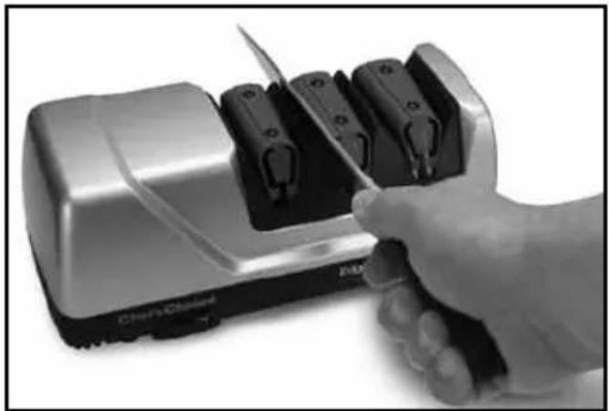 Hand using a Chery Cloned electric shaver to cut black plastic clips (no text or symbols visible)