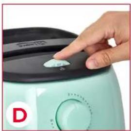 Close-up of a hand pressing a small white object on a light green food appliance (no visible text or symbols)