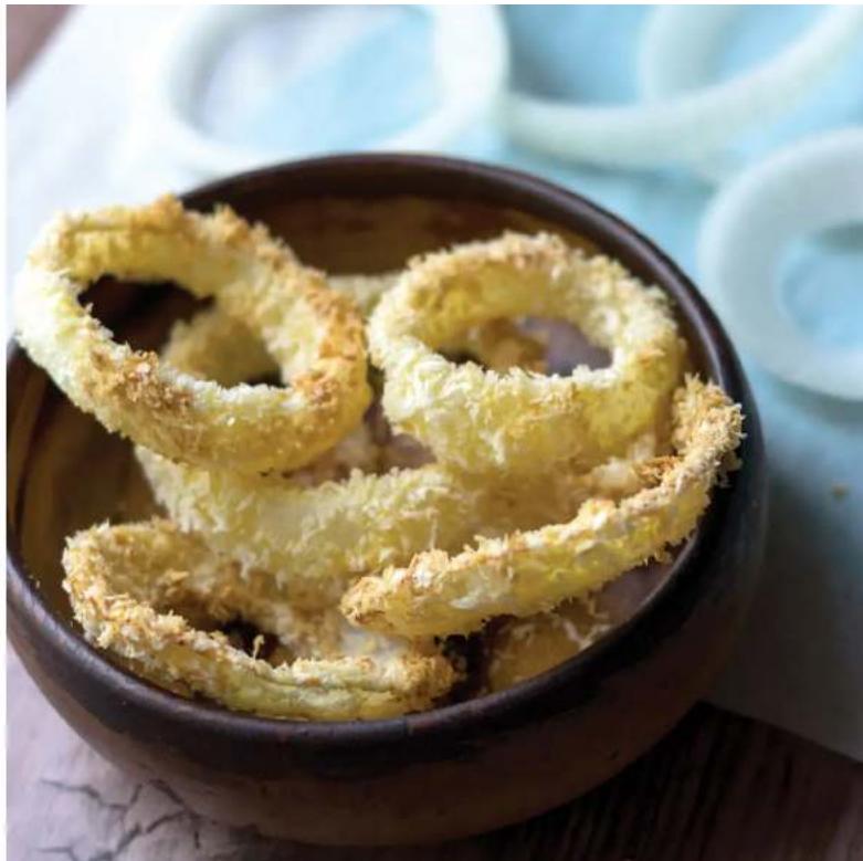 Close-up of golden-brown fried onion rolls in a ceramic bowl, with blurred background items (no text or symbols visible)
