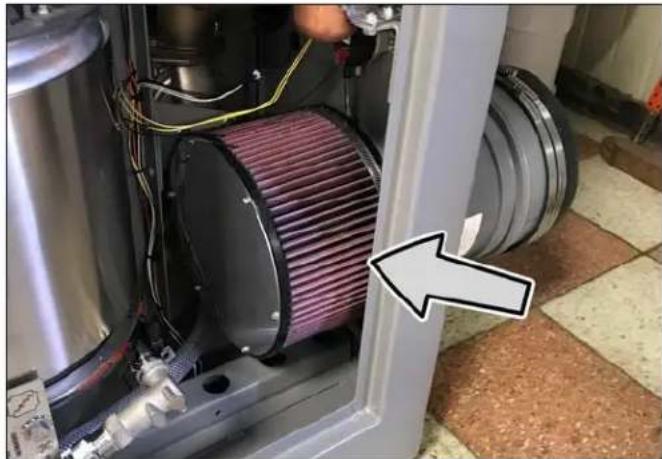 Close-up of a mechanical device with purple filter array and white frame, showing internal components and wiring (no text or symbols visible)