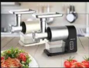Modern kitchen electric shaver with a digital display, surrounded by fresh tomatoes and a plate of bread (no visible text or symbols)