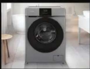 Modern silver washing machine in a minimalist kitchen setting (no visible text or symbols)