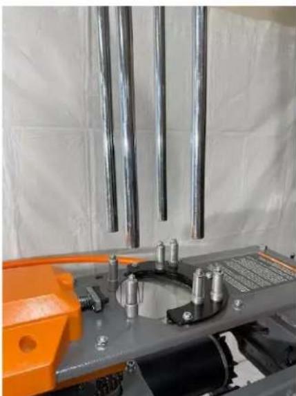 Industrial machine with metal rods and mechanical components, no visible text or symbols