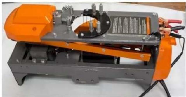 Industrial machine with orange frame and black circular component, no visible text or symbols