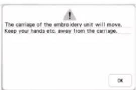 The carriage of the embroidery unit will move. Keep your hands etc. away from the carriage.