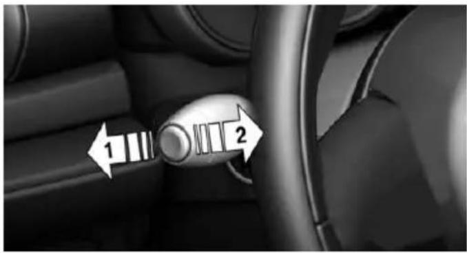 Interior view of a car dashboard with a rotary knob and directional arrows indicating left and right motion (no text or symbols)