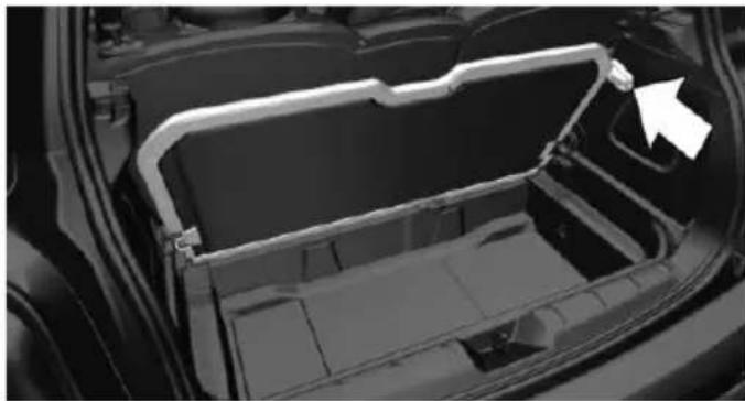 Interior view of a car showing the hood and side panel with a white arrow pointing to a component (no text or symbols visible)