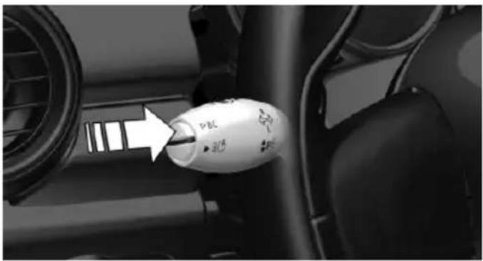 Close-up of a car interior showing a white plastic bottle with 'PBC' label and directional arrow (no readable text or symbols beyond branding)