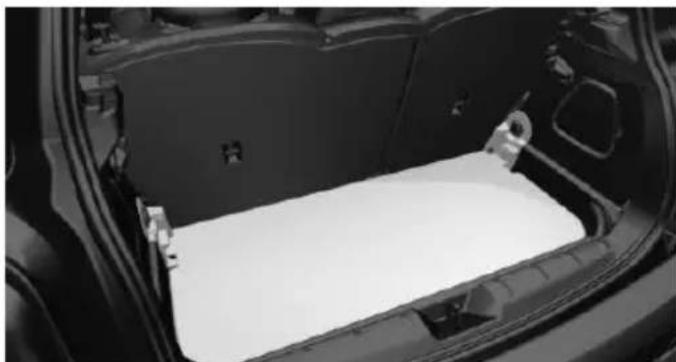 Interior view of a car showing the rear compartment of a vehicle with a white plastic sheet inside (no text or symbols visible)