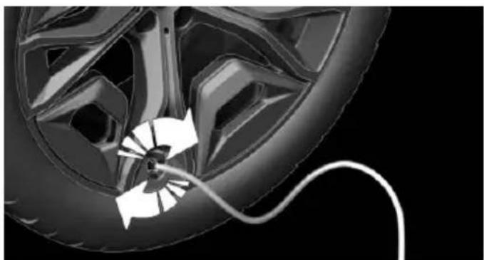 Close-up of a car wheel with a cable inserted, showing mechanical components and motion direction (no text or symbols)