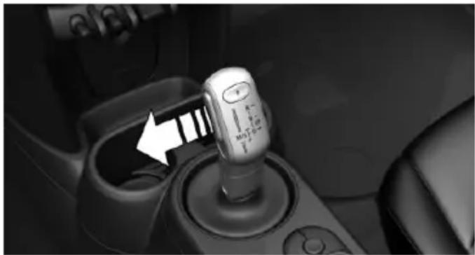 Close-up of a car gear shift lever with a white arrow pointing to the shaft (no visible text or symbols)