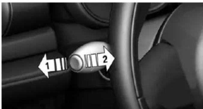 Interior view of a car dashboard with a rotary knob and directional arrows indicating left and right motion (no text or symbols)