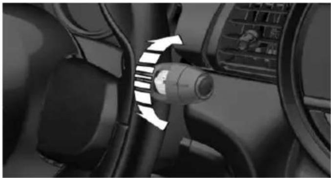 Close-up of a car's seatbelt mechanism with directional arrow indicating rotation (no text or symbols)