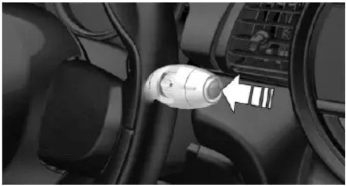 Close-up of a car interior showing a white connector inserted into the seatbelt, with no visible text or symbols.
