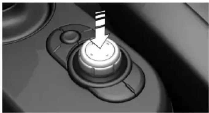 Close-up of a mechanical knob with a white arrow pointing downward (no text or symbols visible)