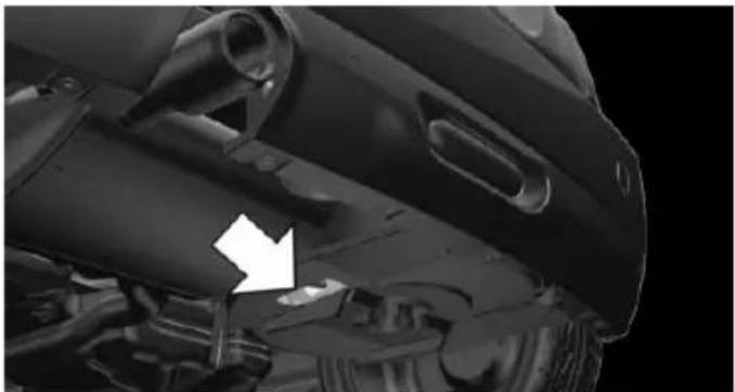 Close-up of a mechanical component with a white arrow pointing to a specific part (no visible text or symbols)
