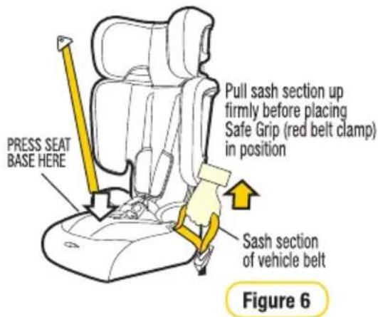 PRESS SEAT BASE HERE Pull sash section up firmly before placing Safe Grip (red belt clamp) in position Sash section of vehicle belt Figure 6